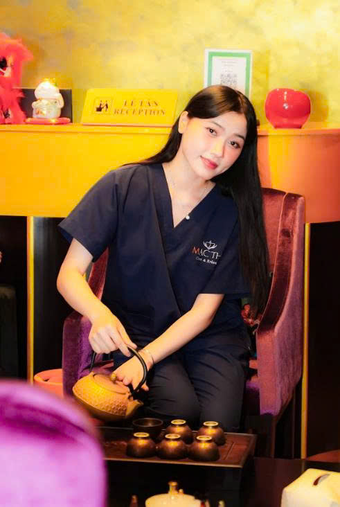 Nhân viên spa mặc đồng phục đang pha trà truyền thống để đón khách